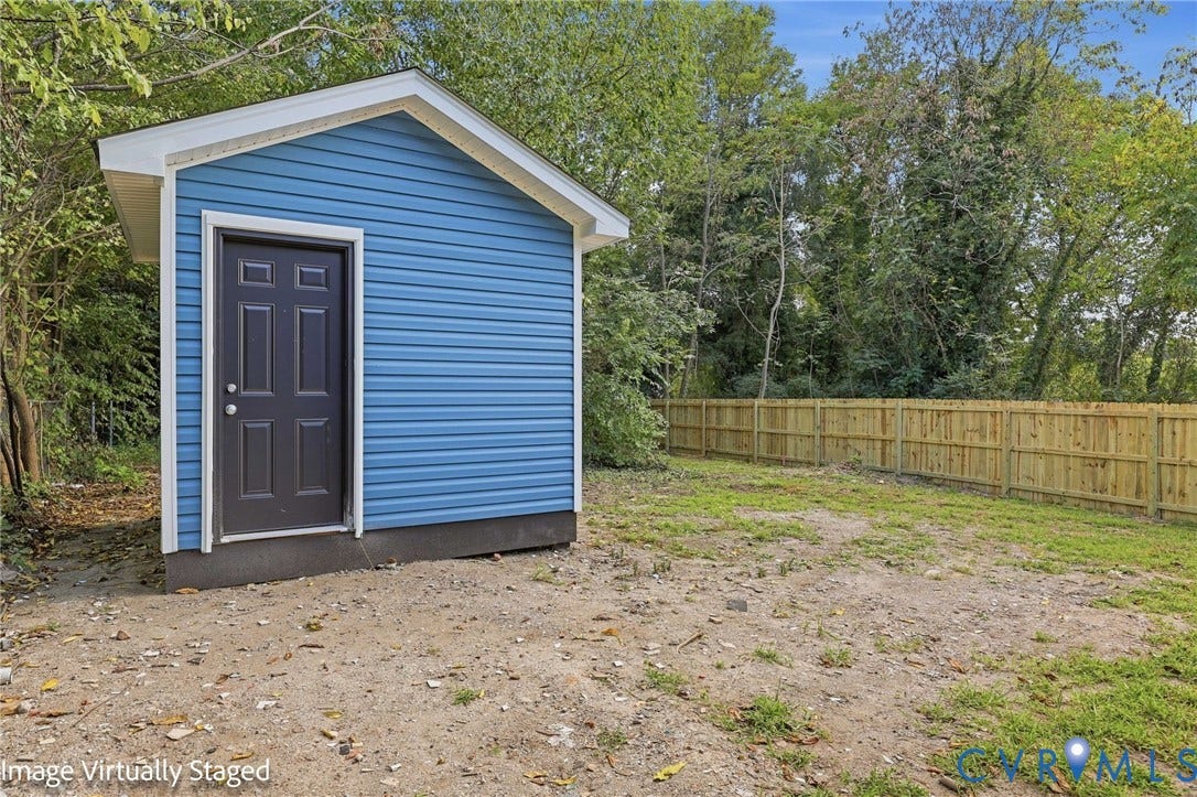 510 N Carolina Avenue, Petersburg, VA 23803 Detached storage shed with blue siding, a dark paneled door, and white trim