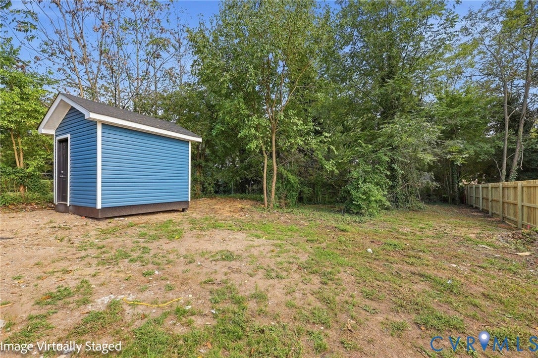 510 N Carolina Avenue, Petersburg, VA 23803 Detached storage shed with blue siding, white trim, and a dark shingle roof