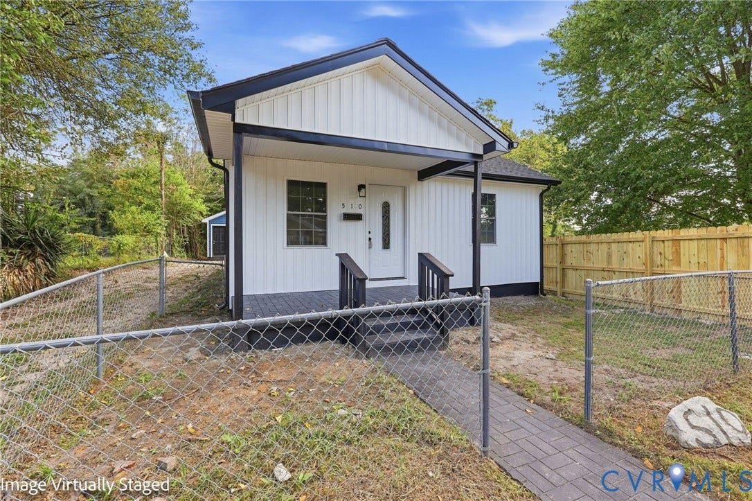 510 N Carolina Avenue, Petersburg, VA 23803 White vertical siding exterior with contrasting black trim, covered porch with dark wood railings, and a front entry door with vertical window inserts