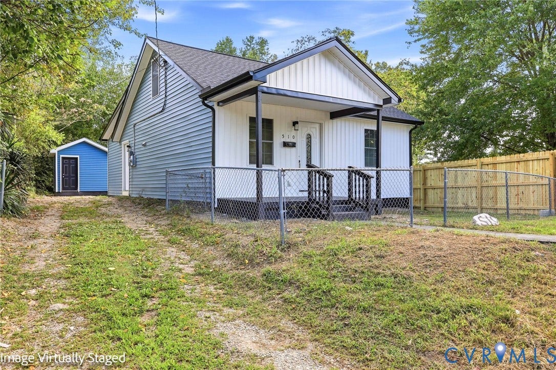 510 N Carolina Avenue, Petersburg, VA 23803 Gabled roofline, light blue and white siding, covered front entry, chain-link front fencing, and a detached shed structure