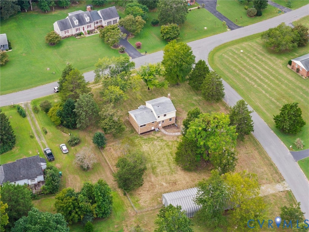 7361 Creekridge Road, Henrico, VA 23231 Aerial property view with a pitched roof residence, surrounding mature trees, a paved driveway, and additional structures on an expansive lot