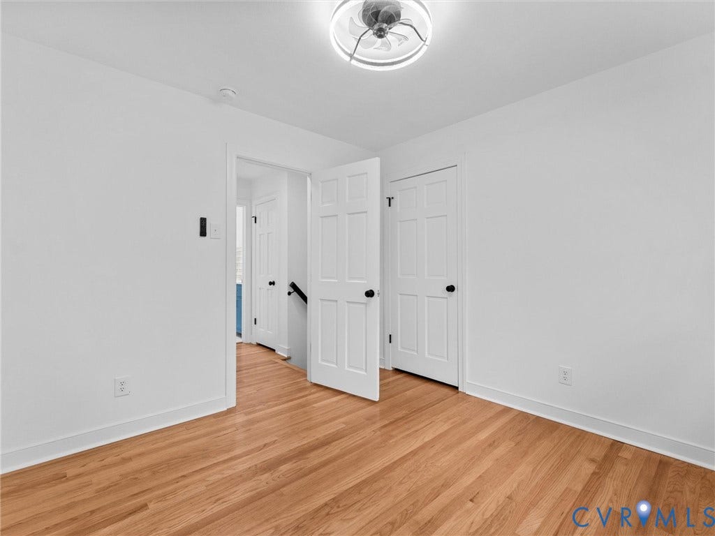 7361 Creekridge Road, Henrico, VA 23231 Wood-finish flooring, white paneled doors with dark hardware, and a ceiling fan with integrated lighting