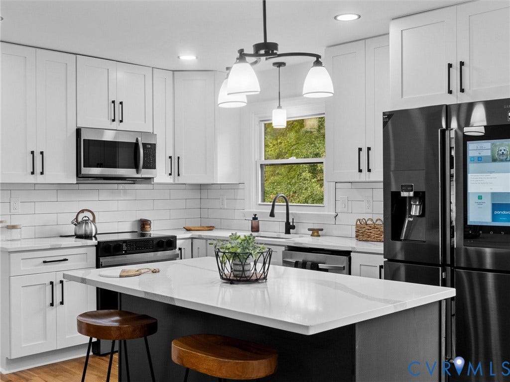 7361 Creekridge Road, Henrico, VA 23231 White shaker-style cabinetry with black hardware, stainless steel appliances, a center island with a light-toned countertop, a subway tile backsplash, and a black faucet