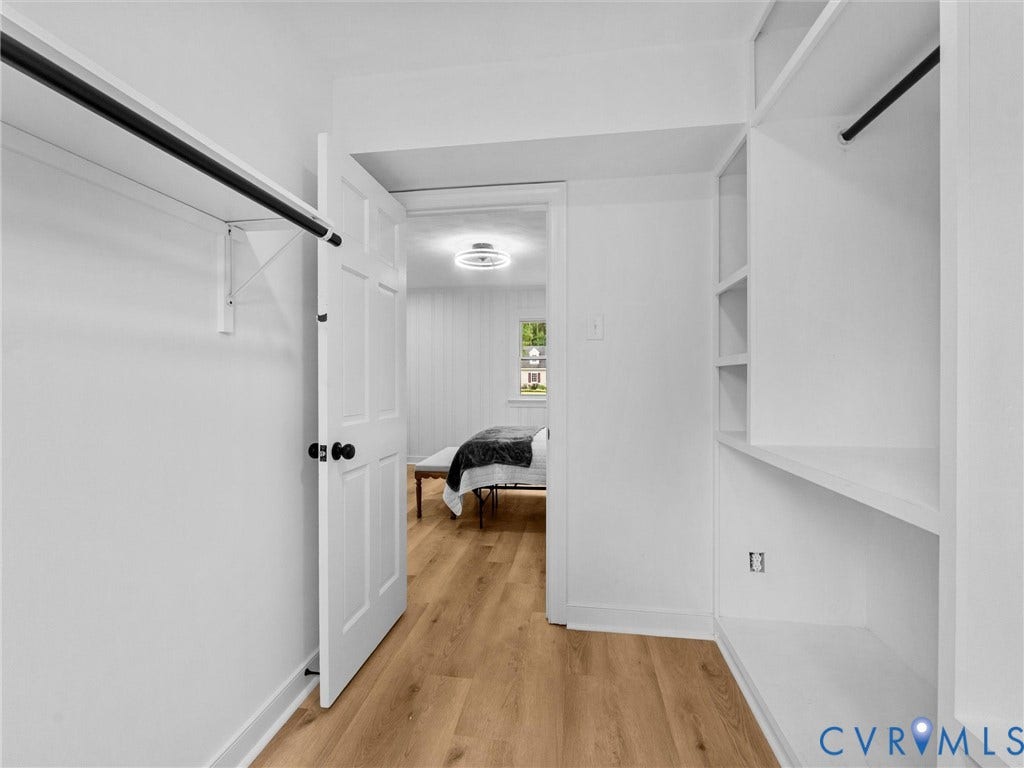 7361 Creekridge Road, Henrico, VA 23231 Built-in shelving, hanging rods, wood-finish flooring, and a paneled door with matte black hardware