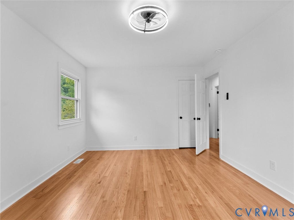 7361 Creekridge Road, Henrico, VA 23231 Hardwood flooring, white walls, double-hung window, white trim, and a modern ceiling light fixture