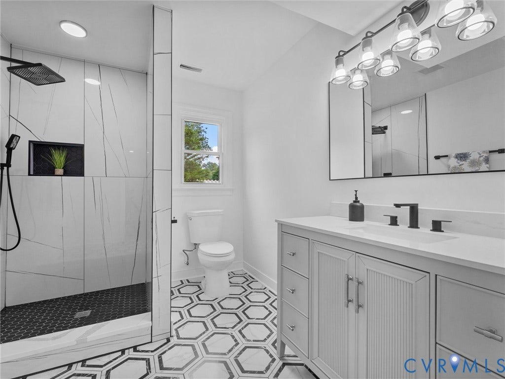 7361 Creekridge Road, Henrico, VA 23231 Walk-in shower with black hexagonal tile flooring and an integrated niche