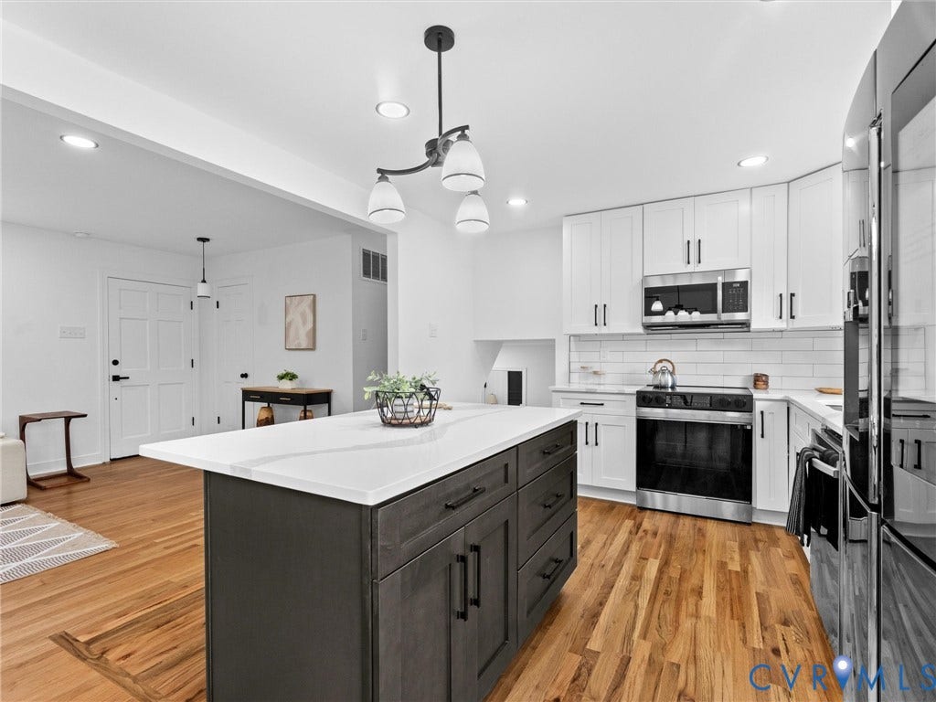 7361 Creekridge Road, Henrico, VA 23231 Kitchen featuring a central island with a light-toned countertop, wood-finish flooring, white upper cabinetry, stainless steel appliances, and recessed lighting