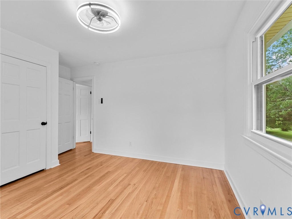7361 Creekridge Road, Henrico, VA 23231 Hardwood flooring, white paneled doors, modern ceiling fan with integrated lighting, and a double-hung window