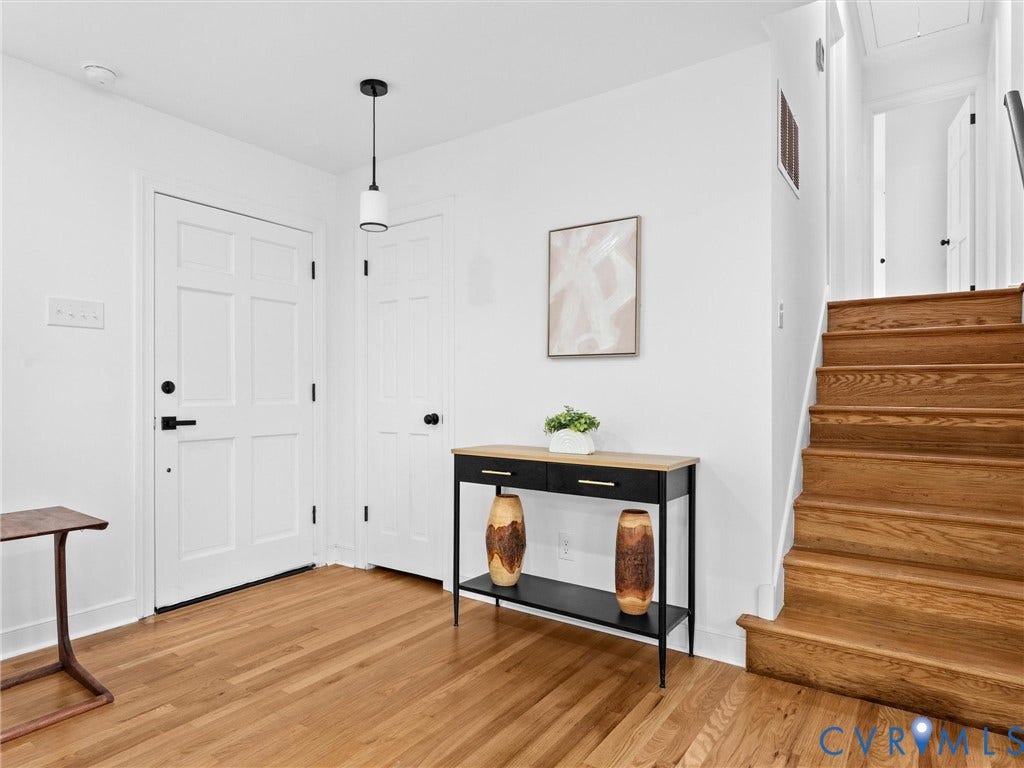 7361 Creekridge Road, Henrico, VA 23231 Wood-finish flooring throughout, white paneled doors with matte black hardware, a modern pendant light fixture, and a wood staircase