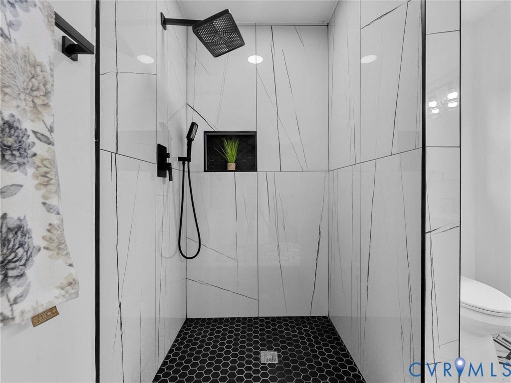7361 Creekridge Road, Henrico, VA 23231 Walk-in shower with white tiled walls and black hexagonal floor tiles