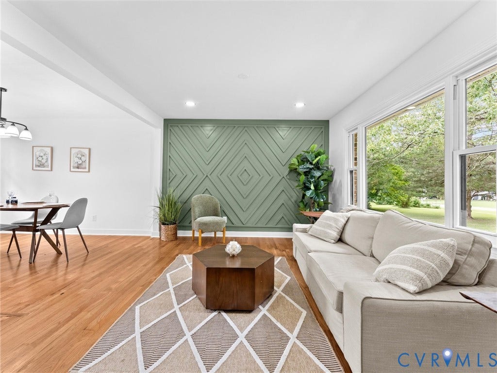 7361 Creekridge Road, Henrico, VA 23231 Wood-finish flooring throughout, recessed ceiling lighting, a distinctive green accent wall with geometric paneling, and large windows providing ample natural light