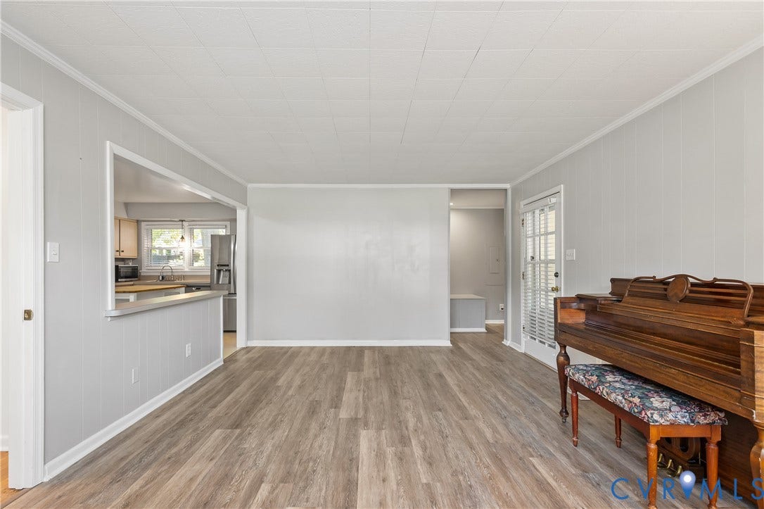300 Gunby Drive, Henrico, VA 23229 Wood-finish flooring, light gray wall paneling, white trim, pass-through window to kitchen, and a white paneled door