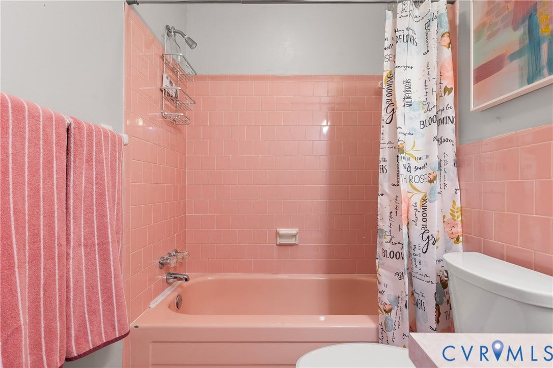 300 Gunby Drive, Henrico, VA 23229 Pink tiled shower surround with a matching pink bathtub, chrome shower fixture, and a built-in soap dish