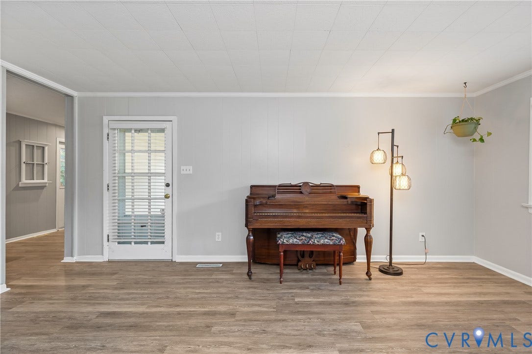 300 Gunby Drive, Henrico, VA 23229 Wood-finish flooring throughout, light gray wall paneling, white trim work, and a paneled white door with glass insert