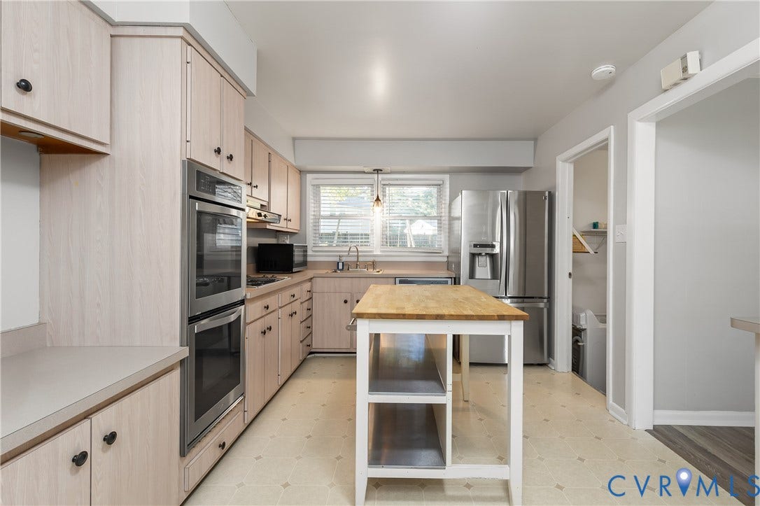 300 Gunby Drive, Henrico, VA 23229 Light wood-finish cabinetry, stainless steel double wall ovens, a center island with wood countertop, and geometric-patterned flooring