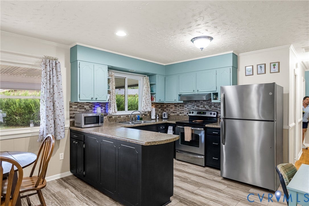 822 Old Town Drive, Colonial Heights, VA 23834 Kitchen featuring wood-finish flooring, light-colored countertops, teal upper cabinetry, dark lower cabinetry, and a mosaic tile backsplash