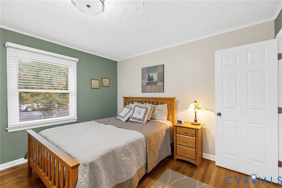 822 Old Town Drive, Colonial Heights, VA 23834 Hardwood flooring, painted paneled accent wall, white trim, and a six-panel interior door