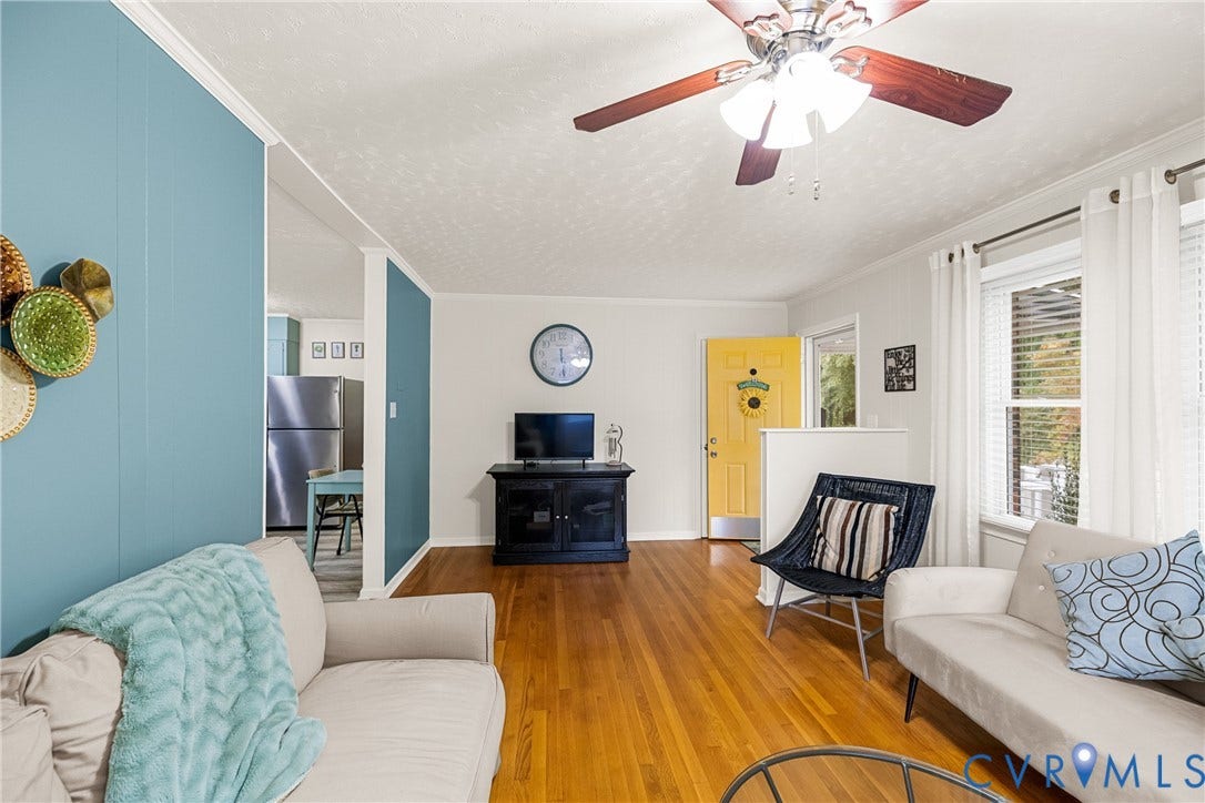 822 Old Town Drive, Colonial Heights, VA 23834 Hardwood flooring, painted accent wall, ceiling fan, multiple windows with blinds, and a brightly colored entry door