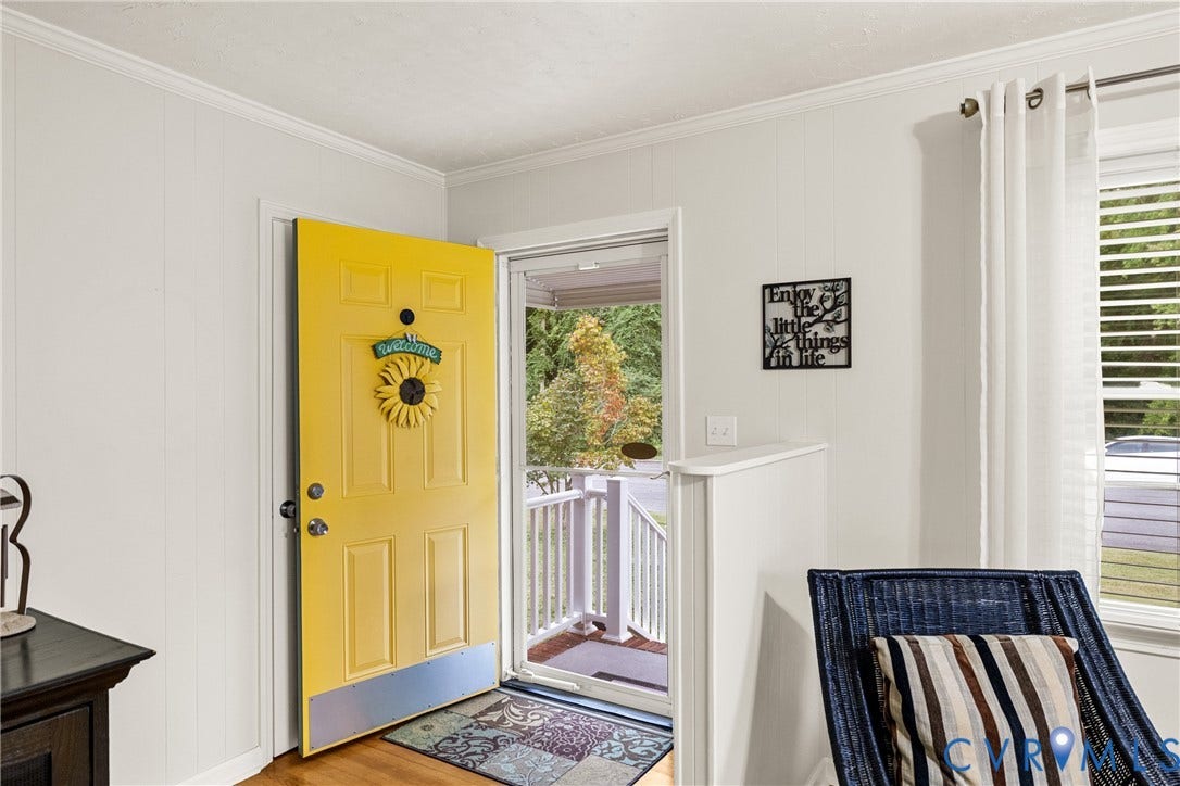 822 Old Town Drive, Colonial Heights, VA 23834 Yellow paneled entry door with white trim, wood-finish flooring, and white wall paneling