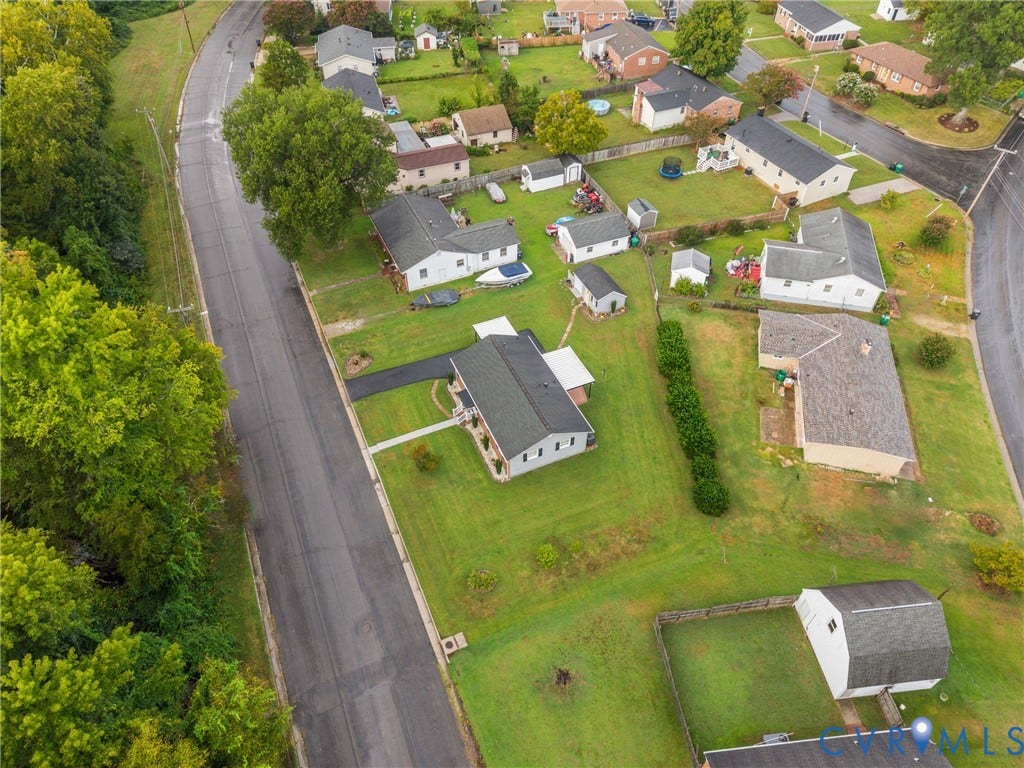 822 Old Town Drive, Colonial Heights, VA 23834 Aerial presentation of a residential property featuring a dark-shingle roof, white exterior siding, and a paved driveway
