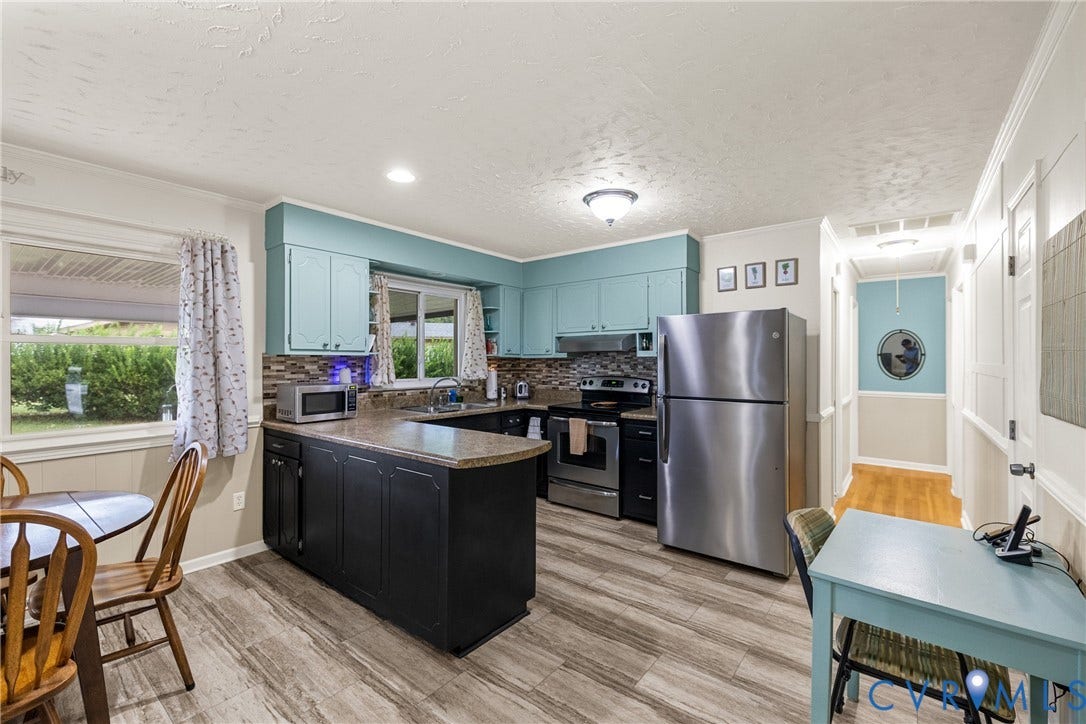 822 Old Town Drive, Colonial Heights, VA 23834 Kitchen featuring blue upper cabinetry, a dark-toned island with countertop, stainless steel refrigerator, and wood-finish flooring