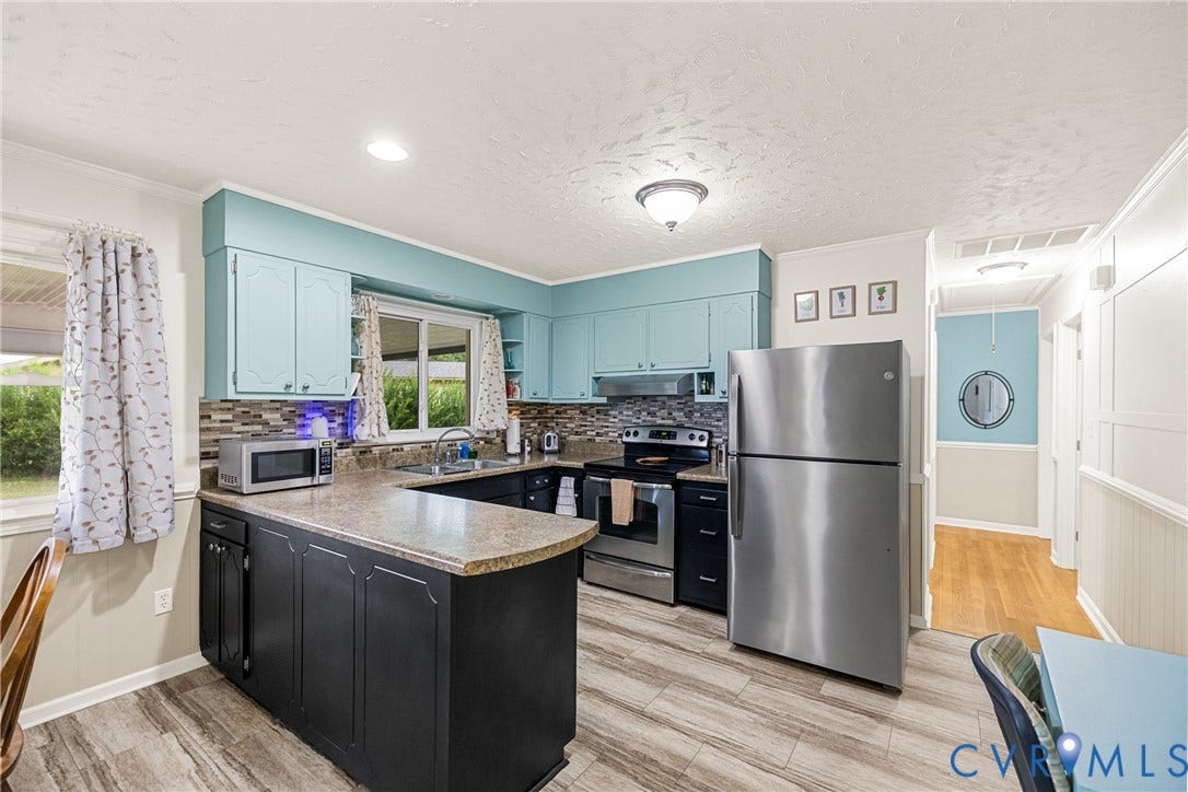 822 Old Town Drive, Colonial Heights, VA 23834 Kitchen featuring wood-finish flooring, two-tone cabinetry, stainless steel appliances, a mosaic tile backsplash, and a breakfast bar