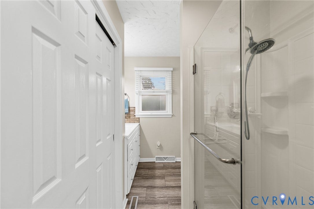 822 Old Town Drive, Colonial Heights, VA 23834 Glass-enclosed shower with a multi-function showerhead, white vanity with multiple drawers, and wood-finish flooring