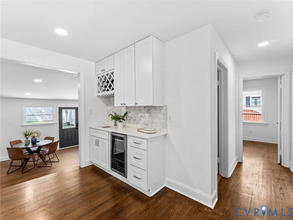 Built-in beverage bar with white cabinetry, granite countertop, and wine refrigerator