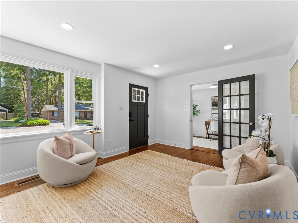 Hardwood flooring, recessed lighting, white walls, and a black French door