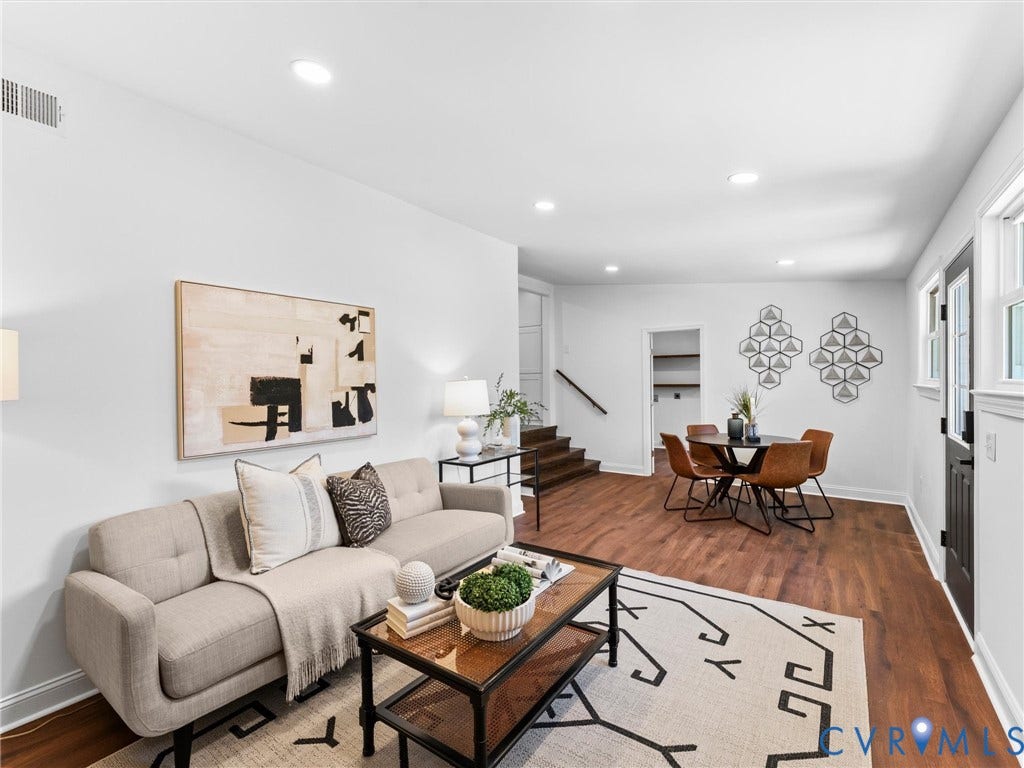 Recessed lighting, wood-finish flooring, white walls, and a black exterior door with rectangular window panels