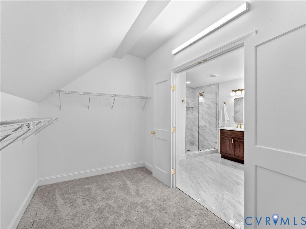 Carpeted closet with wire shelving and angled ceilings