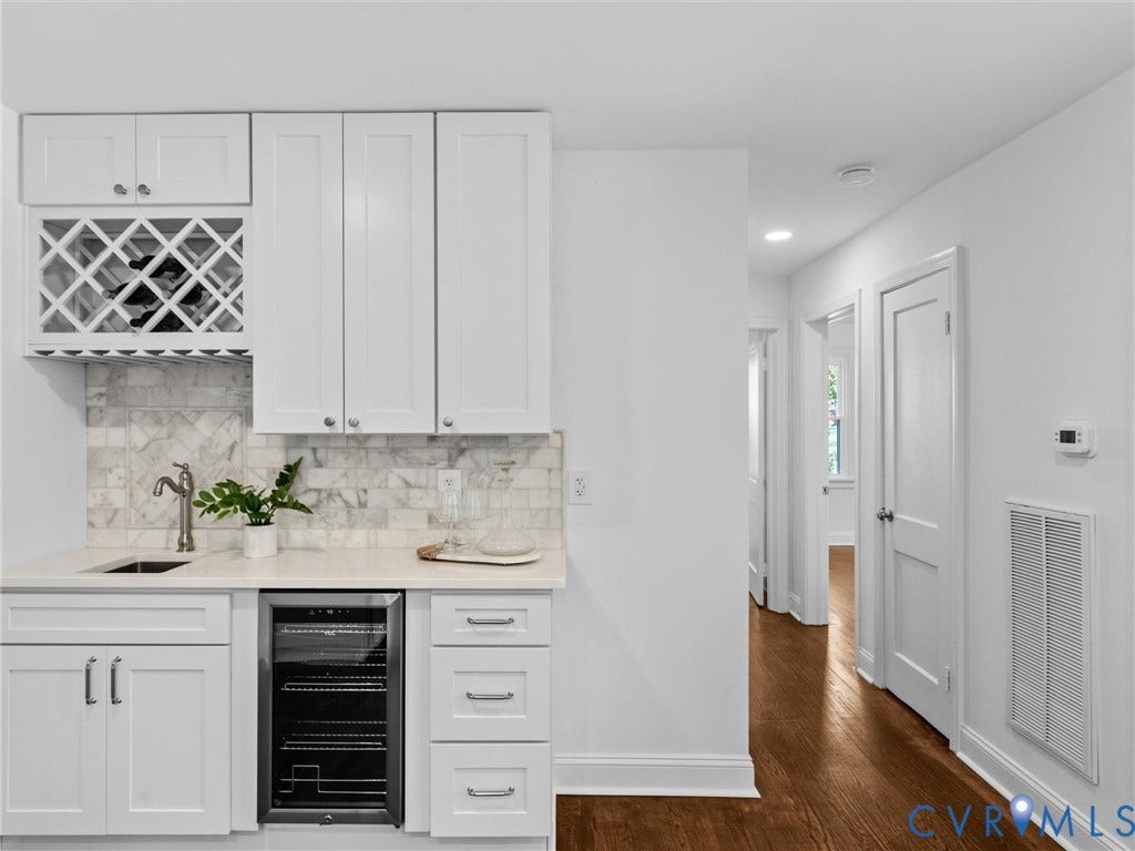 Built-in beverage bar featuring white shaker-style cabinetry, wine storage, and a beverage refrigerator