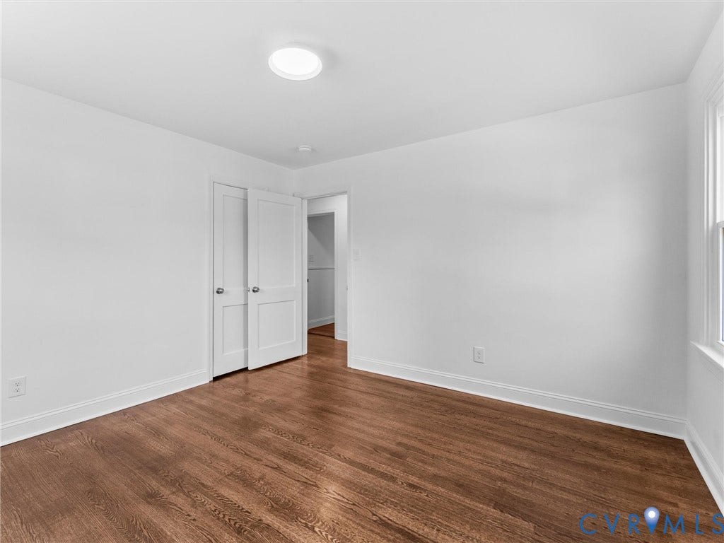 Hardwood-finish flooring, white walls, and a built-in ceiling light fixture