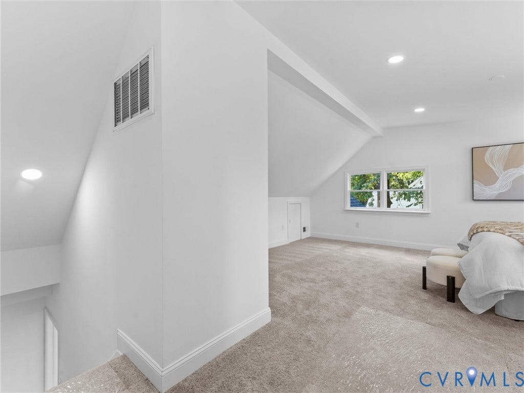 Recessed lighting, sloped ceilings, white trim windows, and plush carpeting