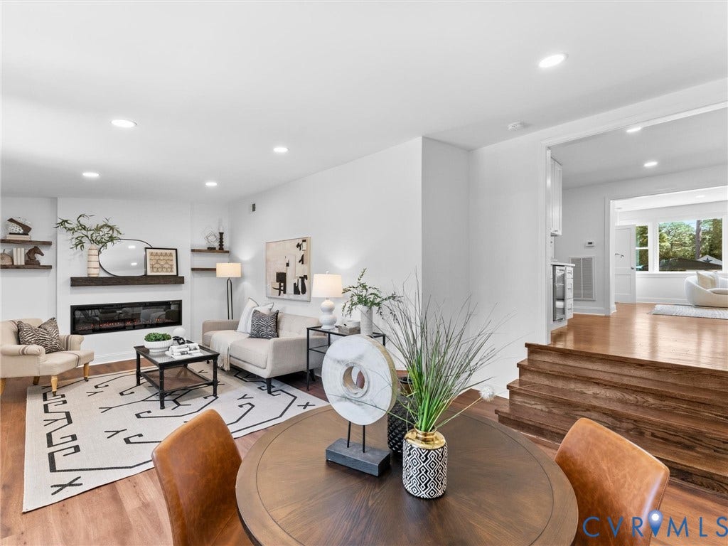Recessed lighting, wood-finish flooring, a linear electric fireplace, and built-in shelving create a contemporary living space