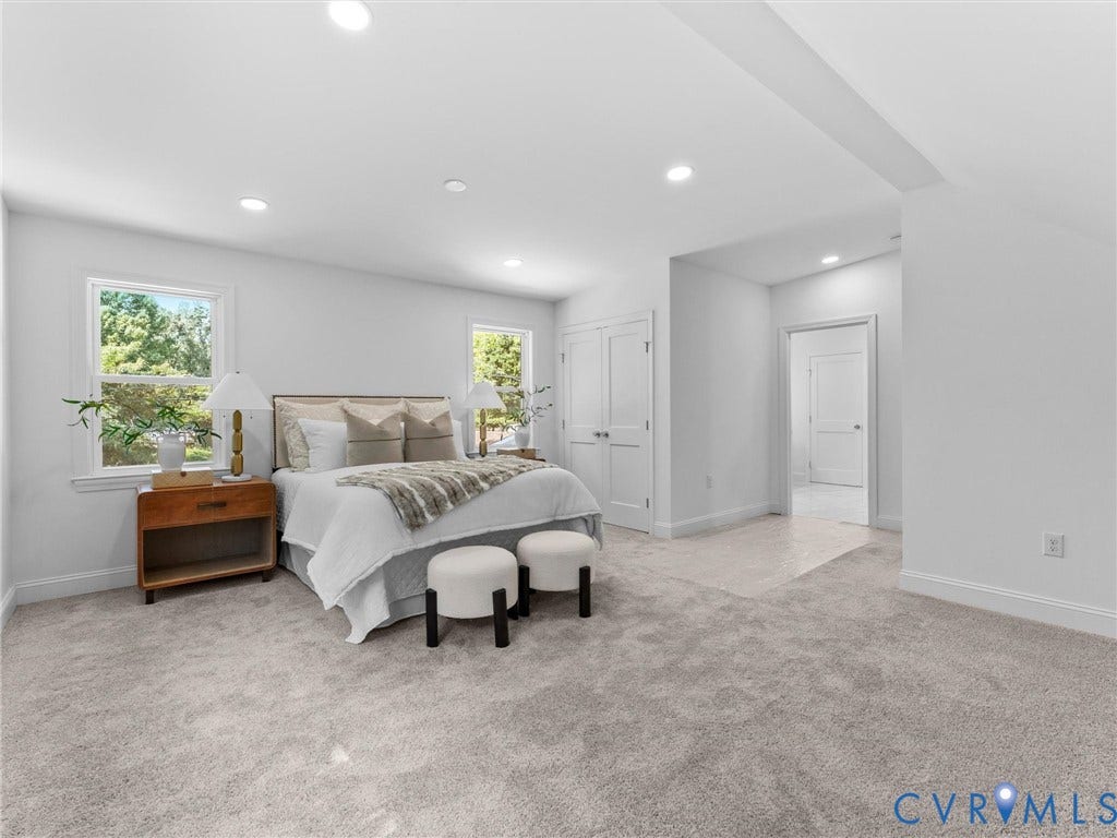 Recessed lighting, light-toned carpeting, white painted walls, and double windows with white trim
