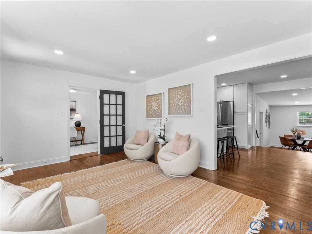 Recessed lighting, wood-finish flooring, white walls, black grid-pane door, and an open concept layout