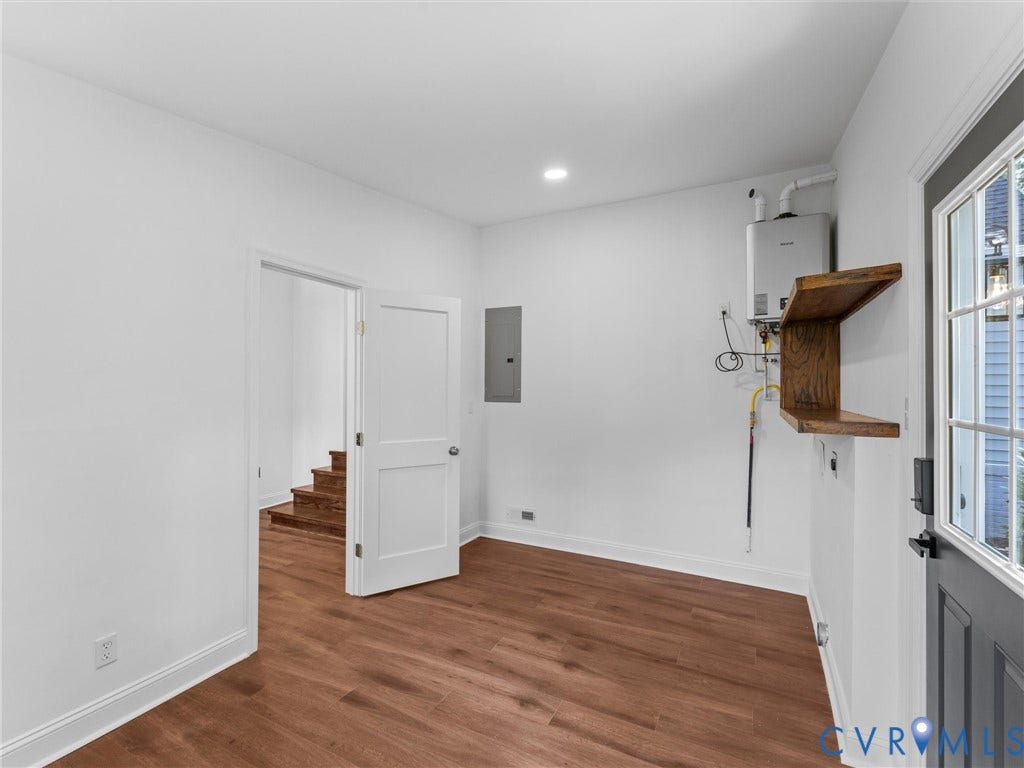 Wood-finish flooring, recessed lighting, and a solid exterior door with window pane