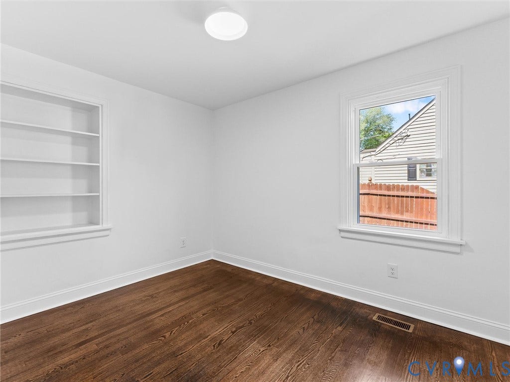 Hardwood-finish flooring, built-in shelving, and a flush-mount ceiling light
