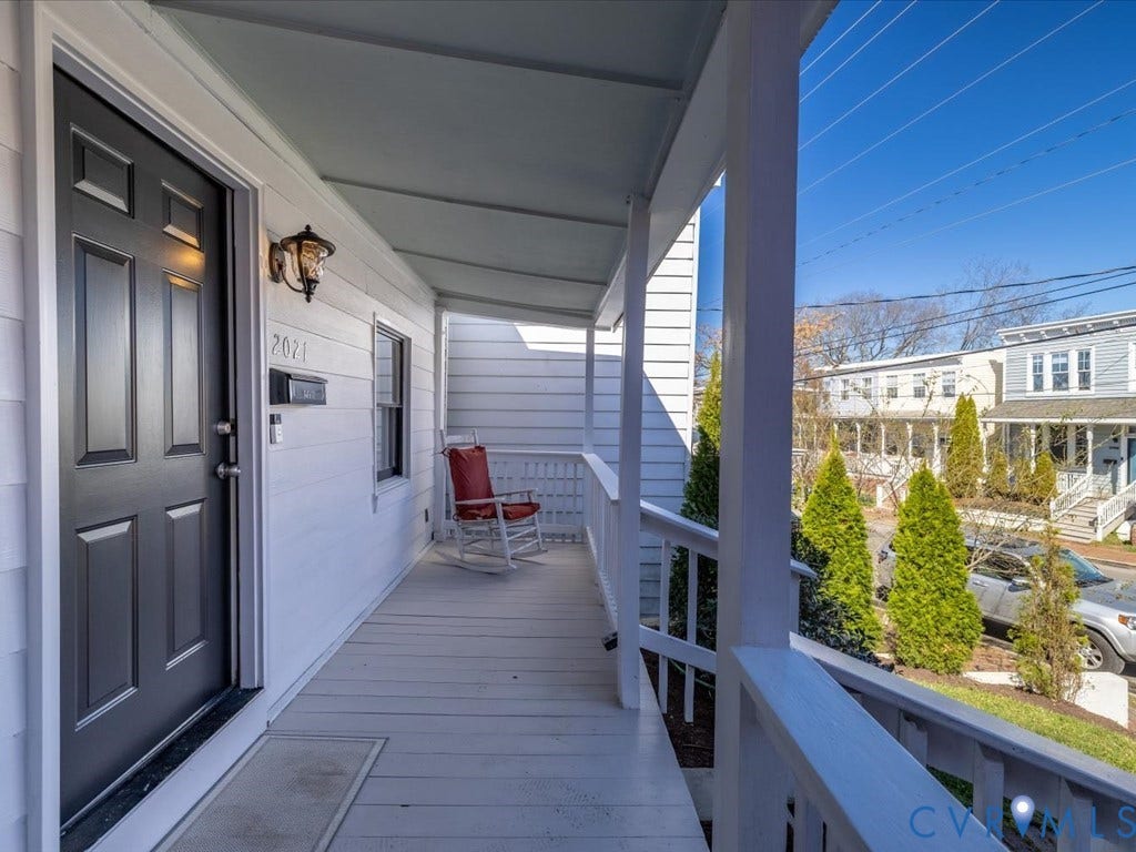 2021 Venable Street, Union Hill, Richmond, VA 23223 Covered porch with white siding, dark paneled entry door, and exterior sconce lighting