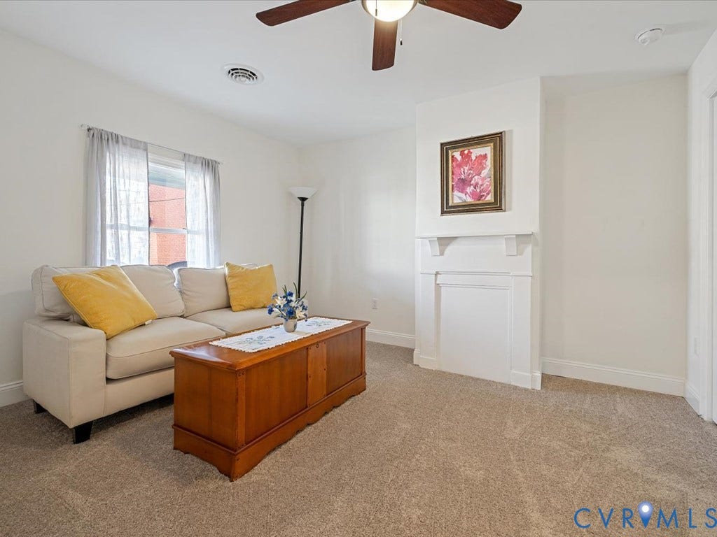 2021 Venable Street, Union Hill, Richmond, VA 23223 Neutral tone carpet flooring, white walls, built-in decorative mantel, ceiling fan with integrated lighting, and a window with natural light