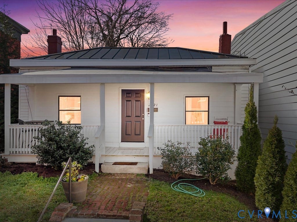 2021 Venable Street, Union Hill, Richmond, VA 23223 White siding exterior with a dark metal roof, a covered front porch, and a brick pathway