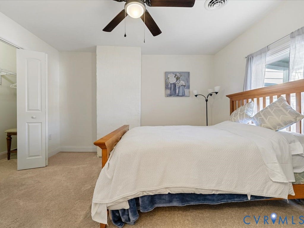 2021 Venable Street, Union Hill, Richmond, VA 23223 Carpeted room featuring a ceiling fan, a window with blinds, and a bi-fold closet door revealing built-in shelving