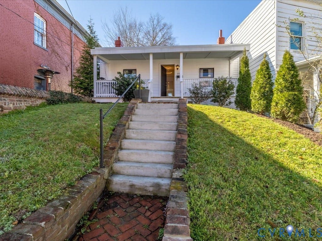 2021 Venable Street, Union Hill, Richmond, VA 23223 White exterior featuring a covered porch with white railings, concrete steps with a metal handrail, and brick retaining walls
