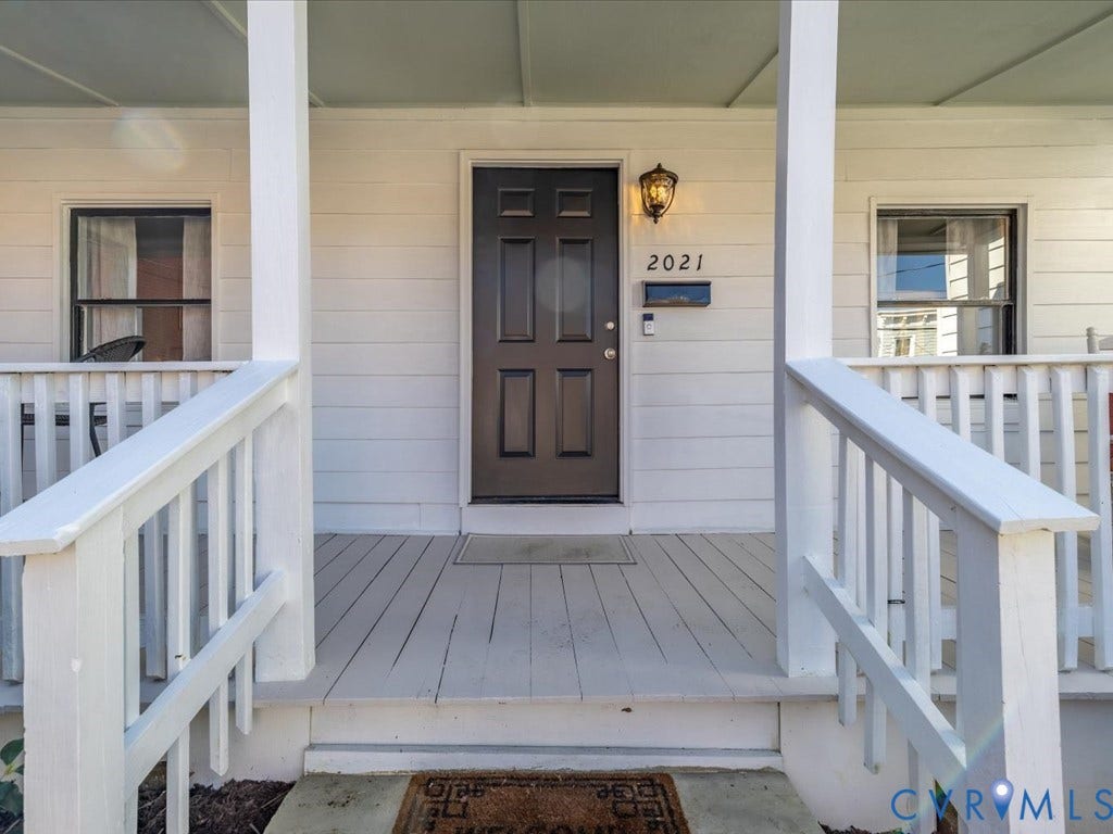 2021 Venable Street, Union Hill, Richmond, VA 23223 Front porch featuring white railings, a dark paneled door, and a wall-mounted light fixture