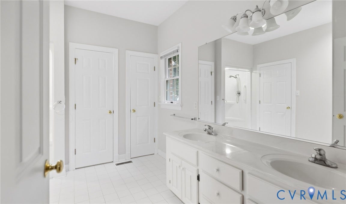 5500 Lakemere Drive, 55+ Community, North Chesterfield, VA 23234 Double vanity with integrated sinks, full-width mirror, white tile flooring, and white paneled doors