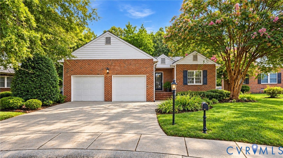 5500 Lakemere Drive, 55+ Community, North Chesterfield, VA 23234 Brick exterior with white siding accents, two-car garage, concrete driveway, front entrance with an exterior light fixture, and a manicured lawn with mature trees