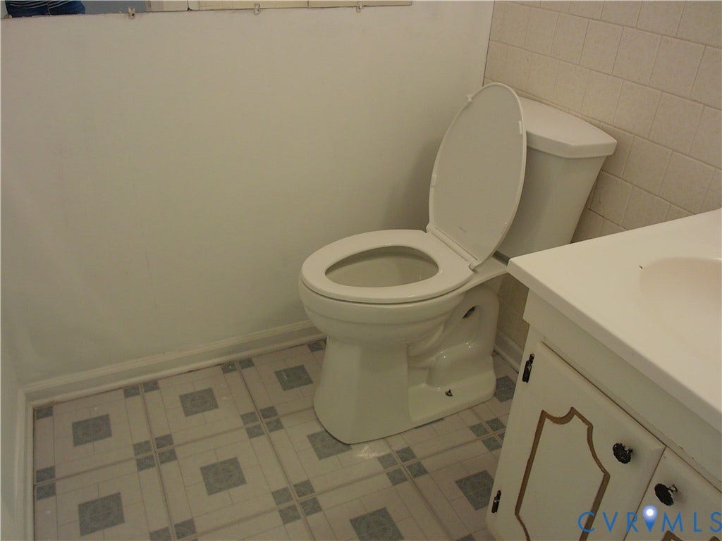 White ceramic toilet with a matching vanity and integrated sink