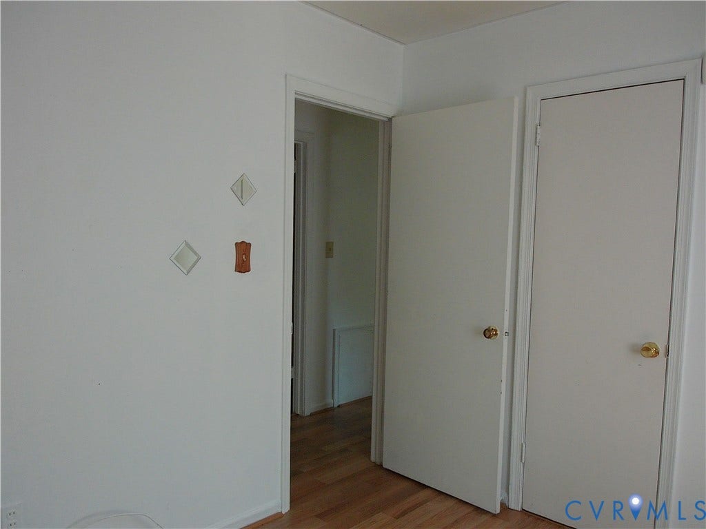 Wood-finish flooring with white interior doors and trim