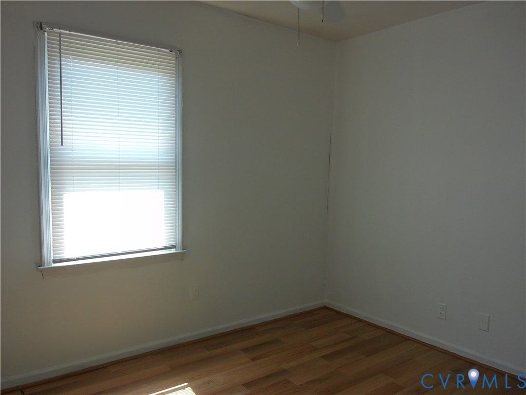 Wood-finish flooring with neutral wall tones and a ceiling fan